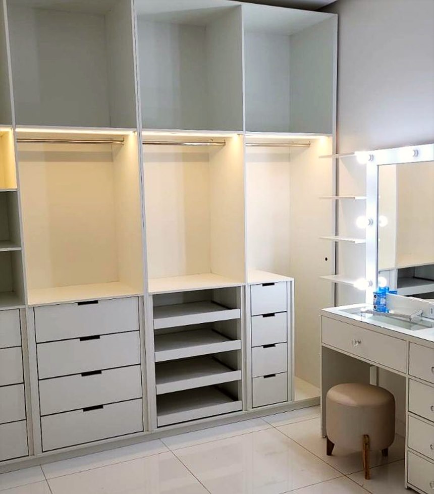 Closet planejado com nichos, gaveteiros e iluminação embutida